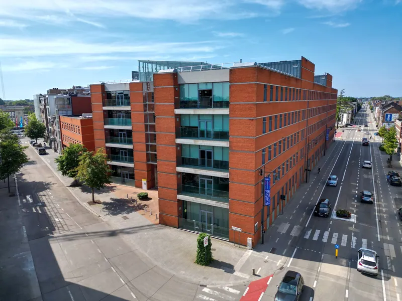 Rood bakstenen stadsgebouw langs een brede straat in Hasselt